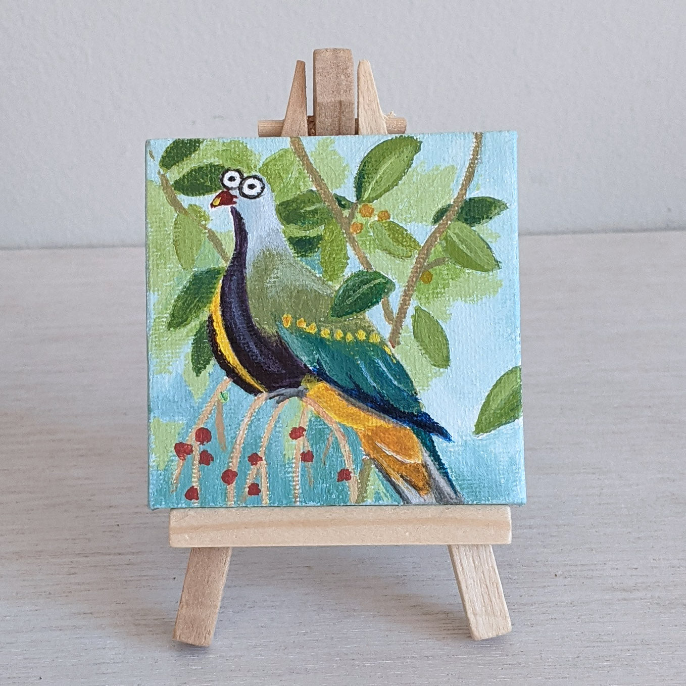 Wompoo fruit dove miniature acrylic painting, with wooden stand. Silly painting.